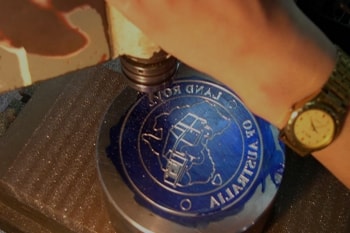 Die sinker adding a logo to metal piece